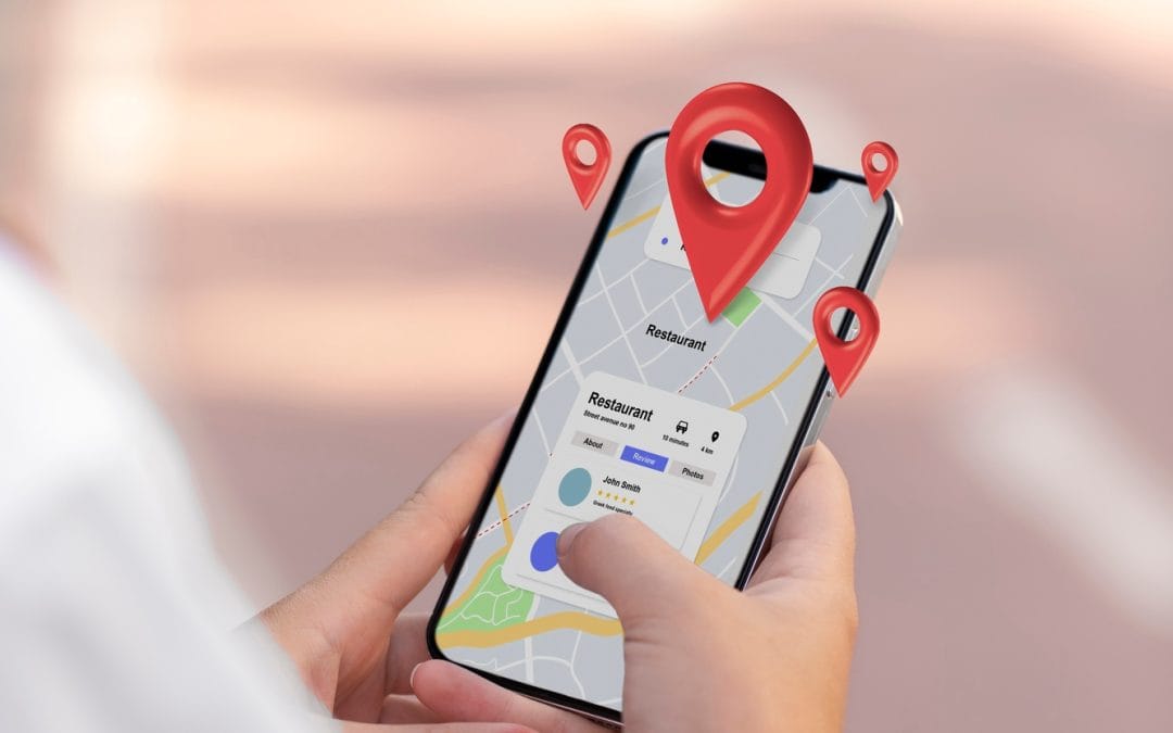 Person holding a smartphone using a map app with red location pins displayed on the screen.